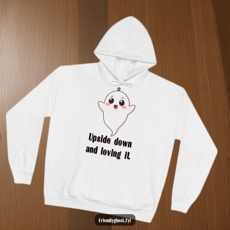 Funny hoodie depicting a ghost with innocent eyes, joyfully giggling while cheerfully hanging upside down, a truly amusing scene.